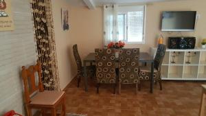 een eetkamer met een tafel en stoelen en een televisie bij Casa Rústica vacacional FILIGRANA en Sanlúcar de Barrameda Zona Montijo in Chipiona