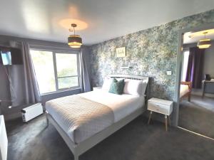 a bedroom with a large bed with floral wallpaper at Lunan House in Arbroath