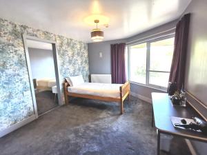a small bedroom with a bed and a mirror at Lunan House in Arbroath