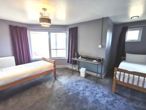 a bedroom with two beds and a sink in it at Lunan House in Arbroath