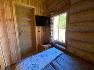1 dormitorio en una cabaña de madera con cama y ventana en Pod Smrekami en Sól