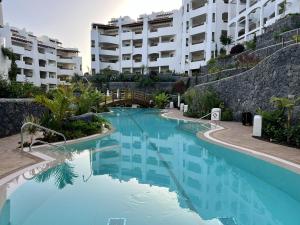 a swimming pool in front of a apartment building at Jardines - Tisaya 11 POOL VIEW & TWIN BEDS 1B in Palm-mar