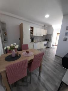 - une cuisine et une salle à manger avec une table et des chaises dans l'établissement Apartman Dujmović 1, à Otočac