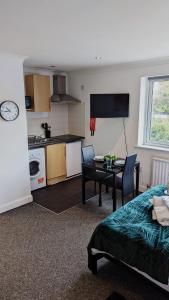 a room with a bed and a kitchen with a table at (S4) Beautiful Studio Close To a Tube Station in Harrow on the Hill