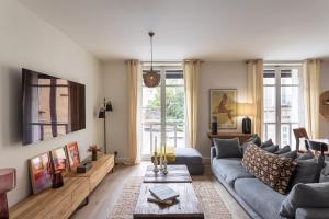 ein Wohnzimmer mit einem Sofa und einem Tisch in der Unterkunft Le Monte Carlo - Appartement 3 chambres en centre ville in Rennes