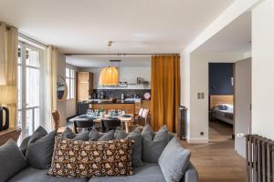 ein Wohnzimmer mit einem Sofa und einem Tisch in der Unterkunft Le Monte Carlo - Appartement 3 chambres en centre ville in Rennes