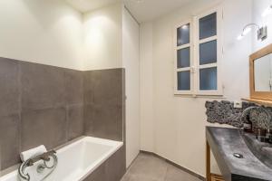 ein Badezimmer mit einer Badewanne und einem Waschbecken in der Unterkunft Le Monte Carlo - Appartement 3 chambres en centre ville in Rennes