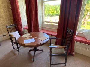 een tafel en twee stoelen in een kamer met een raam bij Rossington Hall in Doncaster