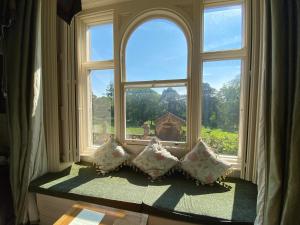 una ventana con cuatro almohadas sentadas frente a ella en Rossington Hall en Doncaster