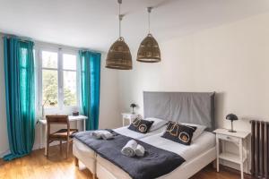 Schlafzimmer mit einem Bett mit blauen Vorhängen und einem Schreibtisch in der Unterkunft Le Monte Carlo - Appartement 3 chambres en centre ville in Rennes