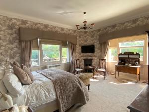 una camera con letto, scrivania e pianoforte di Rossington Hall a Doncaster