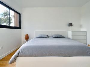 Schlafzimmer mit einem großen weißen Bett und einem Fenster in der Unterkunft Calme, mer et montagne Anglet in Anglet