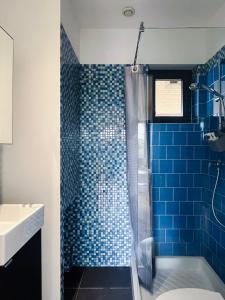 アングレットにあるAppartement Calme, mer et montagne Angletのバスルーム(青いタイル張りのシャワー、シンク付)