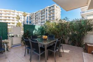 a patio with a table and chairs and a building at Chic and modern apt with terrace - La Croisette in Cannes