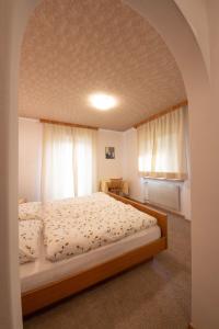 um quarto com uma cama grande num quarto em Ameiserhof Guesthouse em Collalbo
