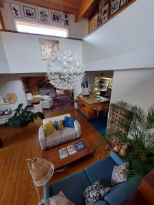 ein Wohnzimmer mit einem blauen Sofa und einem Kronleuchter in der Unterkunft maison de vacances in La Teste-de-Buch