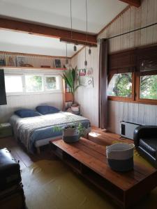 ein Schlafzimmer mit einem Bett und einem Tisch darin in der Unterkunft maison de vacances in La Teste-de-Buch
