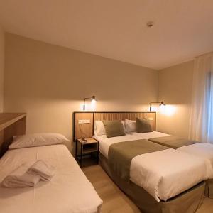 a hotel room with two beds and a window at Hotel Marfany in Andorra la Vella