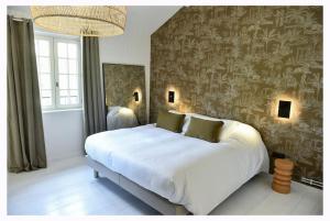a bedroom with a large white bed and a wall with writing at La Maison Rose, chaleureuse et luxueuse in Roanne