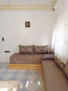 een kleine slaapkamer met een bed en gordijnen bij appartement 2chambres et un salon in Chefchaouene