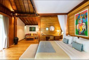 a bedroom with a large bed and a living room at Govinda Villas in Penginyahan
