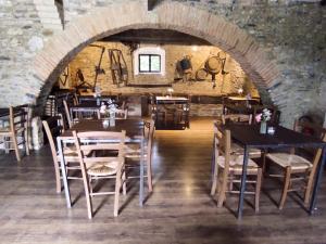 a dining room with tables and chairs and a brick wall at Casale Regnano in Lama