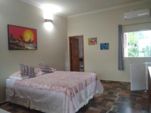 um quarto com uma cama e uma janela em Toca do Guaiamum I em Ubatuba