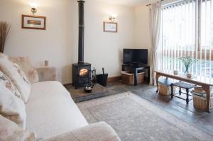a living room with a couch and a wood stove at The Old School Cottage Ship Farm - 1 Bedroom - Rhossili in Rhossili