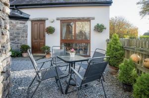 a table and chairs in front of a house at The Old School Cottage Ship Farm - 1 Bedroom - Rhossili in Rhossili