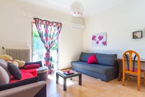una sala de estar con 2 sofás y una ventana en Mema's Tranquil Apartment in Patra, en Patra