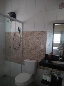 uma casa de banho com um WC, um chuveiro e um lavatório. em Toca do Guaiamum I em Ubatuba