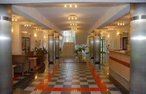 um corredor de um edifício com piso em xadrez em Sport Hotel em Debrecen