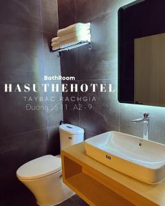 ein Badezimmer mit einem weißen WC und einem Waschbecken in der Unterkunft Hasu The Hotel in Rạch Giá
