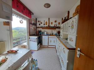 a kitchen with white appliances and a large window at Cosy house in picturesque Jura in Doucier