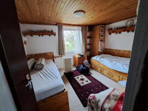 a small bedroom with two beds and a window at Cosy house in picturesque Jura in Doucier