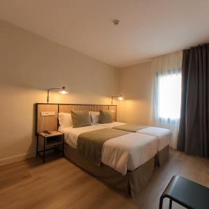 Un dormitorio con una cama grande y una ventana en Hotel Marfany en Andorra la Vella
