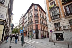 una calle de la ciudad con edificios y gente caminando por la calle en Hostal Esparteros en Madrid