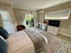 a bedroom with a bed and a flat screen tv at Constantiaberg Eco-Villa in Cape Town