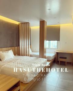 een hotelkamer met een bed en een bureau bij Hasu The Hotel in Rach Gia