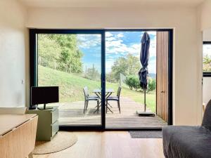 a living room with a sliding glass door with a table and chairs at Calme, mer et montagne Anglet in Anglet