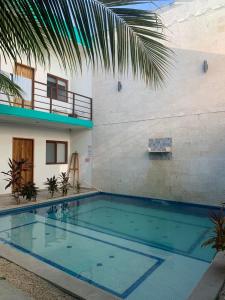 a swimming pool in front of a house at Los Arcos Hotel - TULUM in Tulum