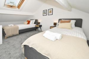 Duas camas num quarto com paredes brancas em Victoria House by YourStays, City Centre, free parking, sleeps 6 em Stoke-on-Trent