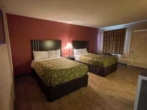 東哈特福德的住宿－Economy Inn，酒店客房设有两张床和红色的墙壁。
