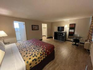 una camera d'albergo con letto e TV di Economy Inn a East Hartford