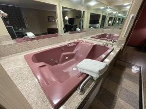 a pink sink in a bathroom with a large mirror at Economy Inn in East Hartford