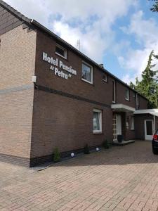 een gebouw met een bord aan de zijkant bij Hotel Pension Petra in Bad Zwischenahn