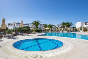 ein Swimmingpool in einem Ferienresort mit Liegestühlen und Sonnenschirmen in der Unterkunft Irini Hotel in Afiartis