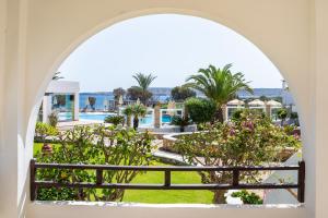 an archway view of the pool from a resort at Irini Hotel in Afiartis