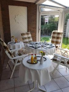 two tables and chairs sitting on a patio at Hotel Pension Petra in Bad Zwischenahn