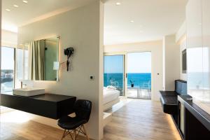 a bathroom with a sink and a desk with a mirror at Kahlua Sea View Suites in Hersonissos